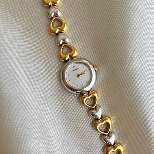 Front view of the Seiko two-tone heart bracelet watch with pearl dial.