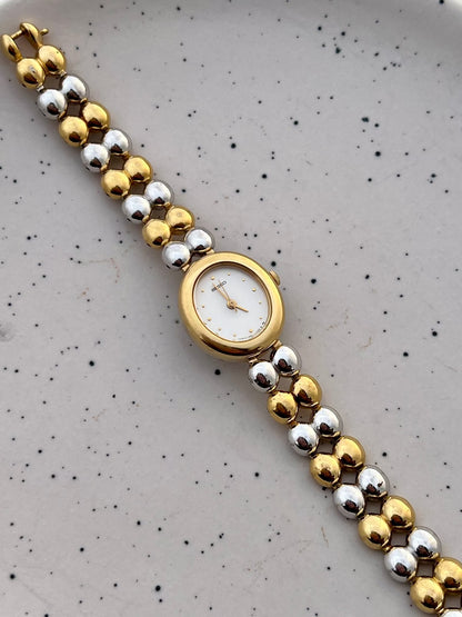 Angled view of the Seiko oval watch case and two-tone bead bracelet.