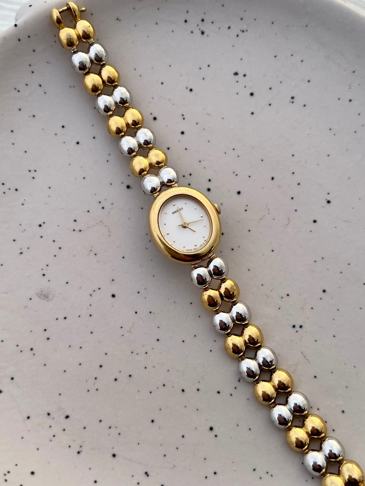Caseback detail of the Seiko two-tone oval bracelet watch.