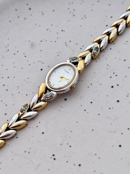 Front view of the Seiko oval watch with gold-tone case and two-tone leaf bracelet.