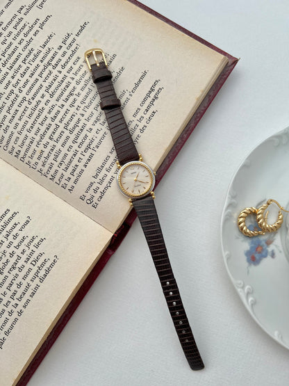 Seiko Two Toned Rope Bezel Woman's Watch — the watch laid flat with jewellery nearby.