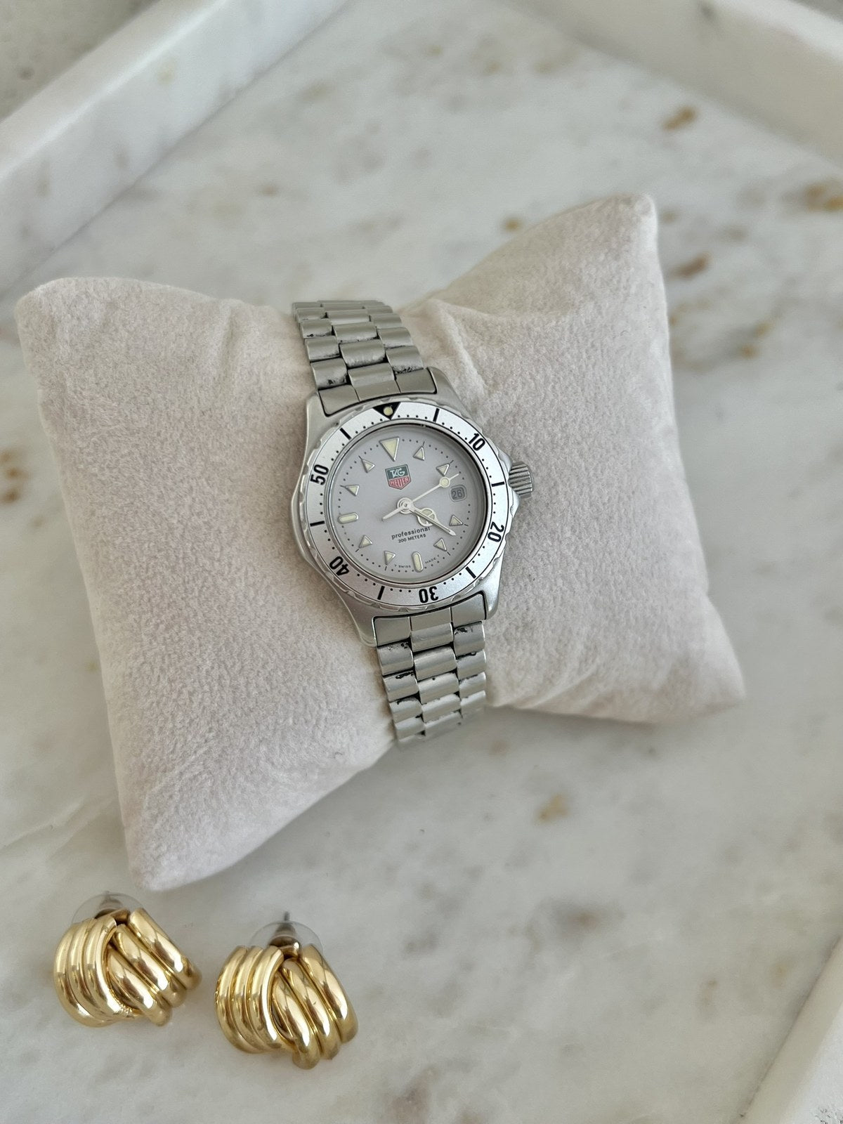 TAG Heuer 2000 Professional watch on steel bracelet, displayed on a cream cushion