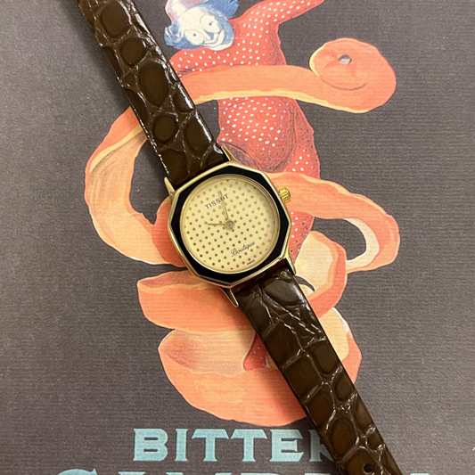 Front view of the Tissot Boutique gold-tone hexagonal watch with black enamel bezel and brown leather strap.