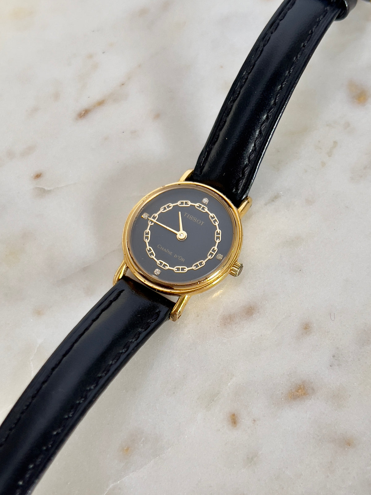 Tissot Chaîne d’Or Black Dial Chain Motif Women’s Watch; black stitched leather strap and gold tone buckle. Product photograph 9 of 10.