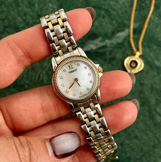 Front view of the Tissot petite two-tone watch with mother-of-pearl dial and diamond accents.