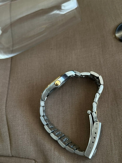 Side profile of the Tissot PR 50 showing the gold tone signed crown and open deployant clasp