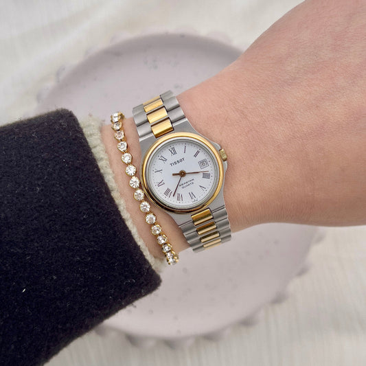 Tissot Seastar two-tone ladies watch with white Roman numeral dial and integrated bracelet.