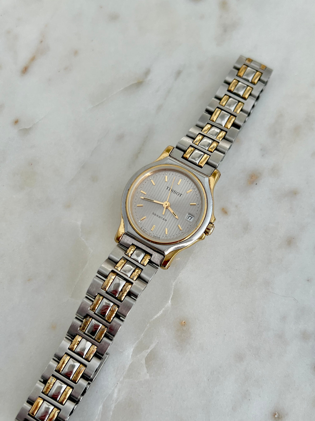 Side profile of the Tissot Seastar case and gold-tone crown.