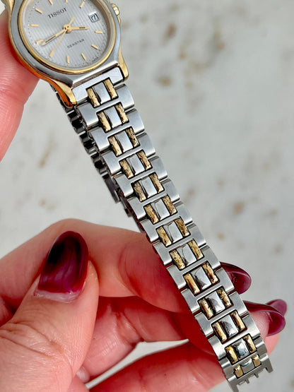 Tissot Seastar quartz watch with silver guilloche dial and gold accents.
