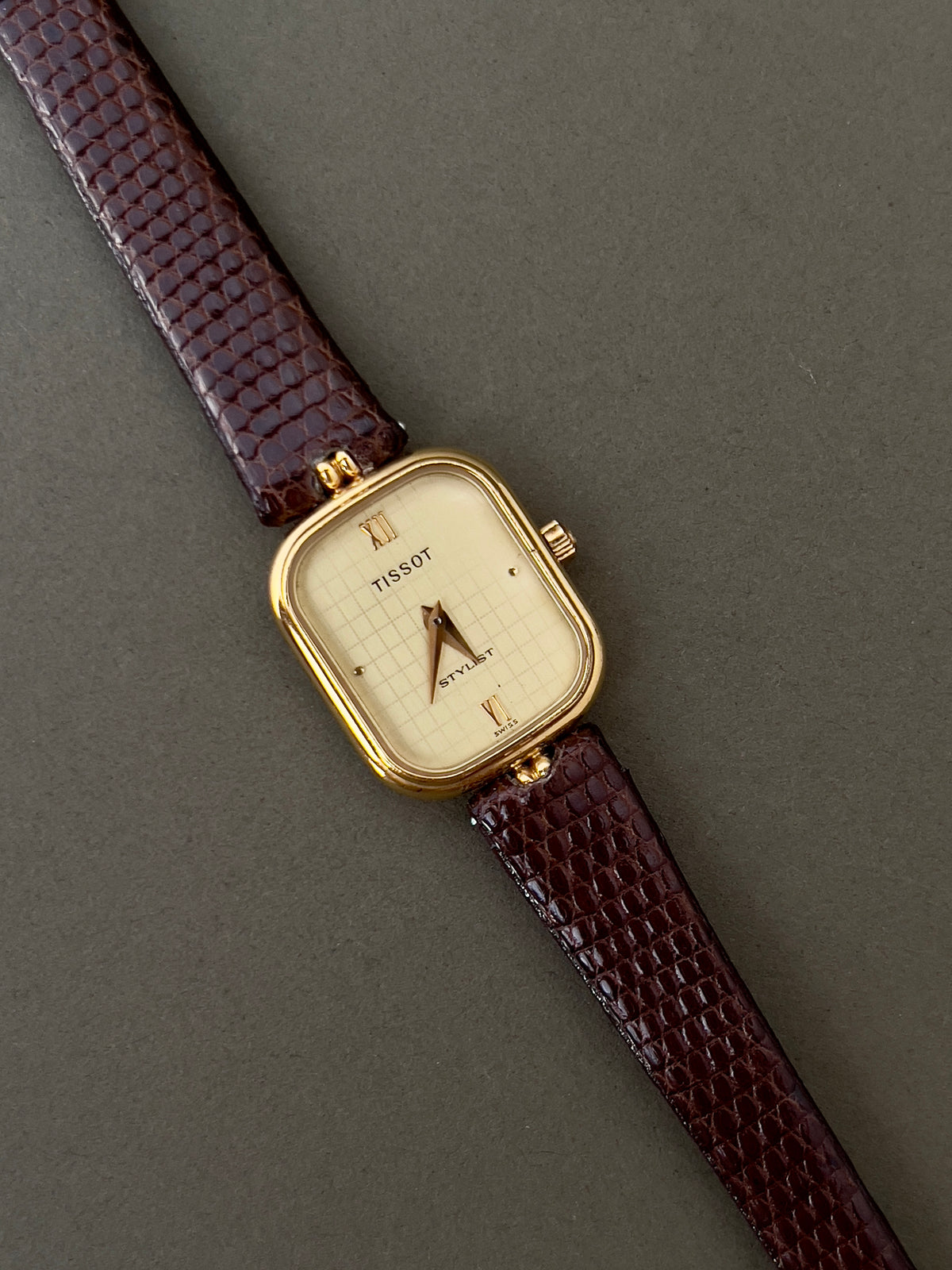 Tissot Stylist Gold Cushion Women’s Watch with Patterned Dial — front view of cushion dial and brown strap.