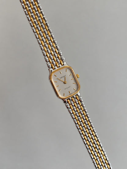 Tissot Stylist rectangular silver dial watch displayed with the two tone bracelet extended.