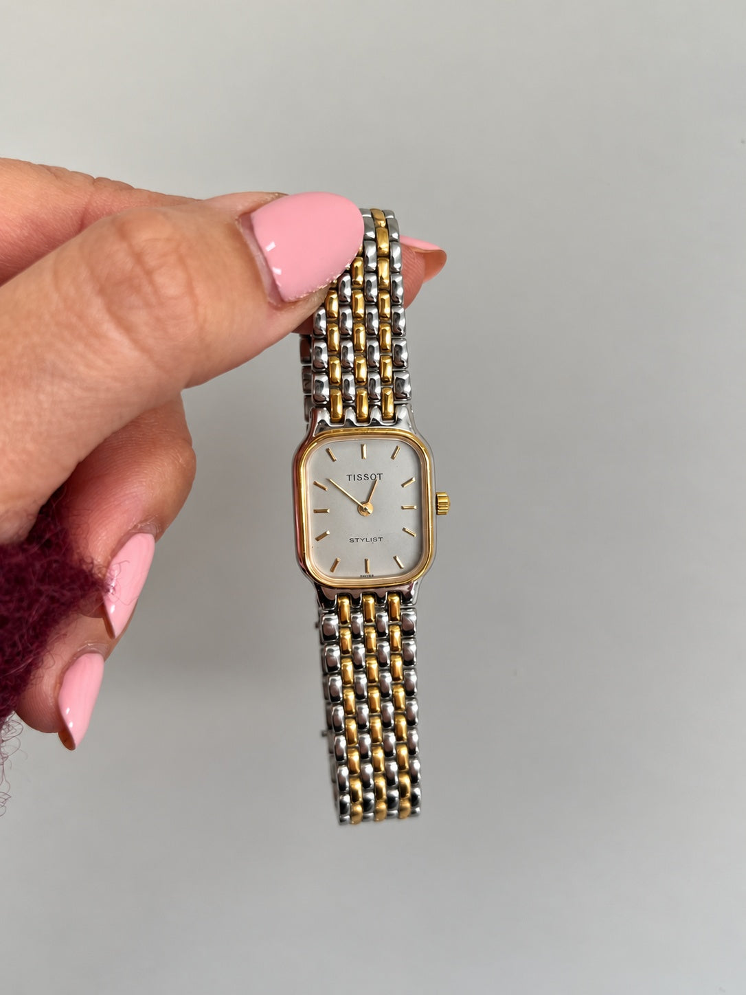 Tissot Stylist pale silver dial with applied gold tone markers and slender two hand display.