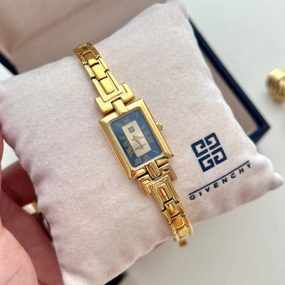 Vintage Givenchy women’s gold-tone bangle watch with a rectangular blue Roman numeral dial and geometric bracelet displayed in a Givenchy presentation box
