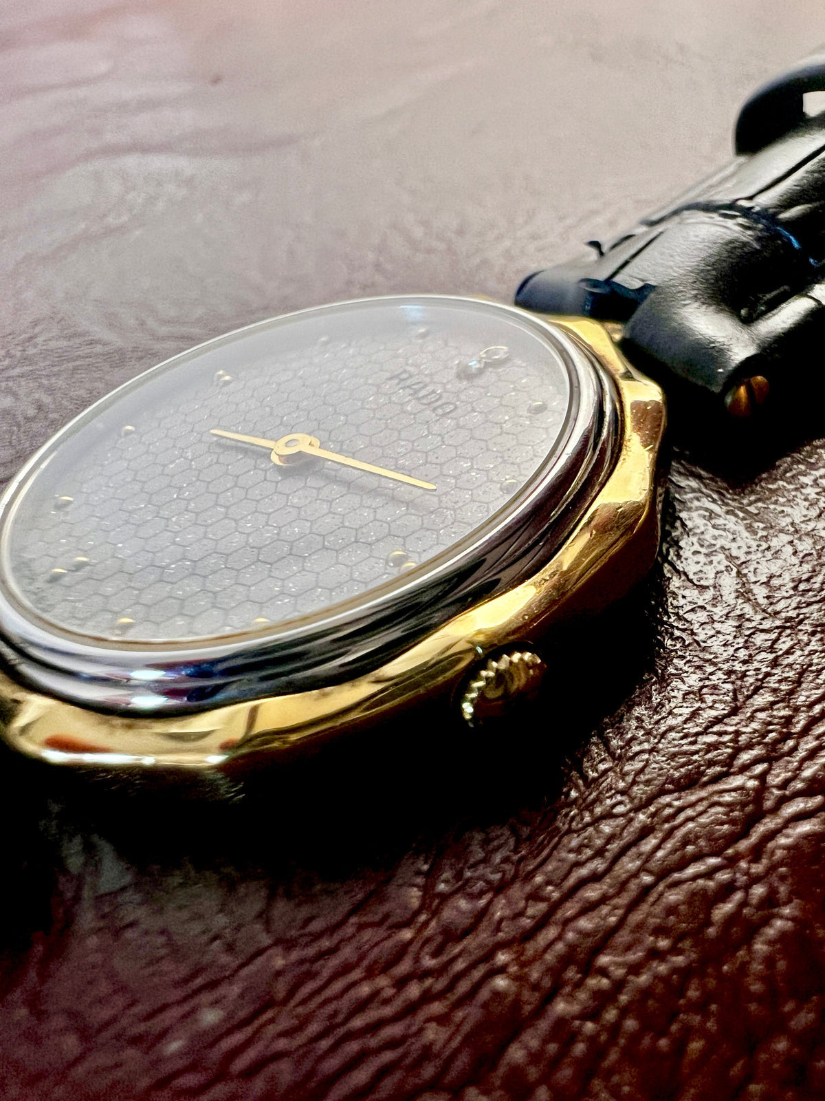 Vintage Rado women's watch with a flower-shaped two-tone case and honeycomb dial, shown at an angle to reveal the petal-shaped case.