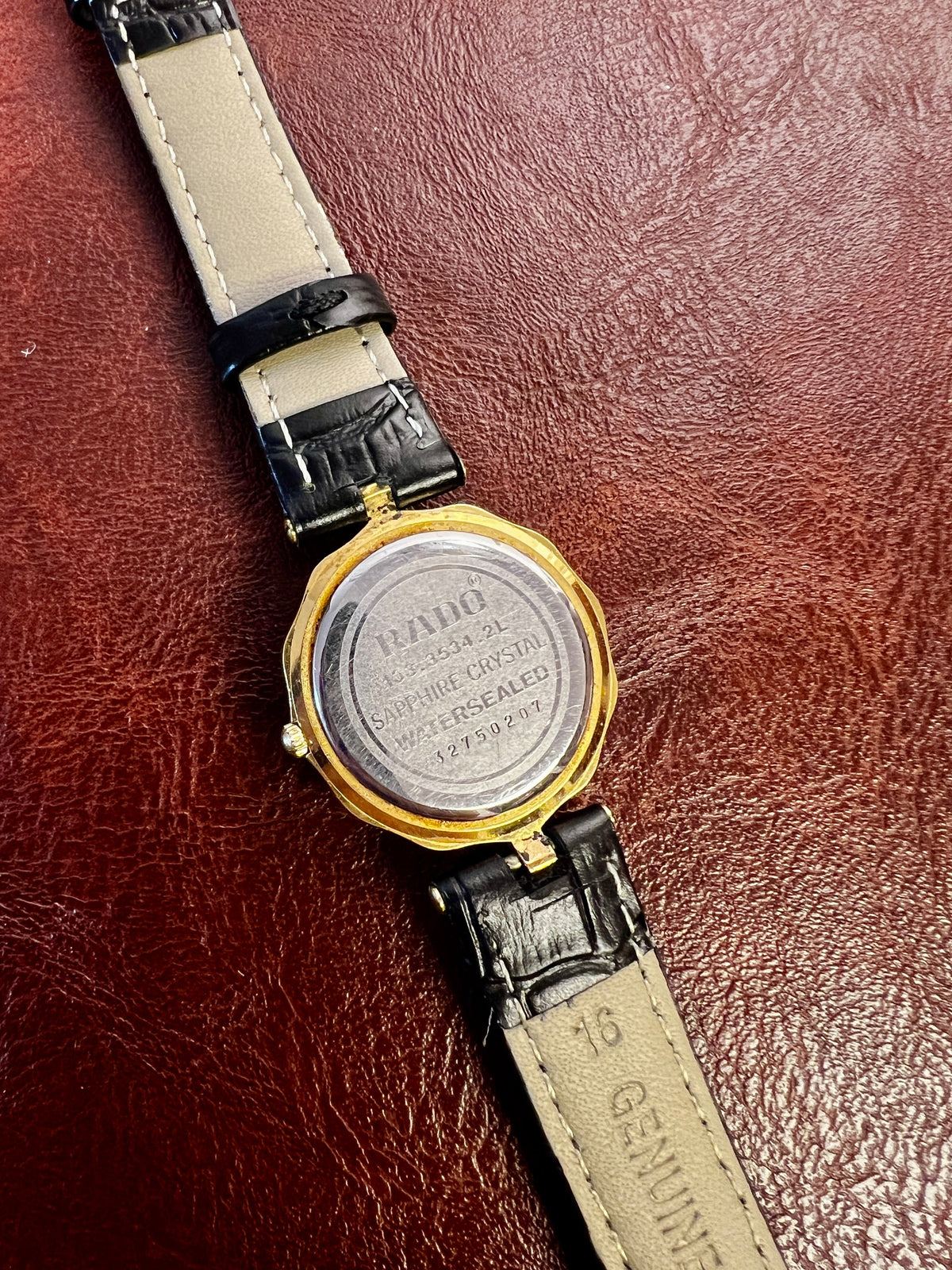 Vintage Rado women's watch with a flower-shaped two-tone case and honeycomb dial, shown from the back.