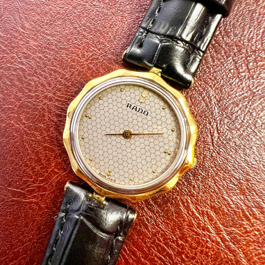Vintage Rado women's watch with a flower-shaped two-tone case and honeycomb dial, shown in a close view of the honeycomb dial.