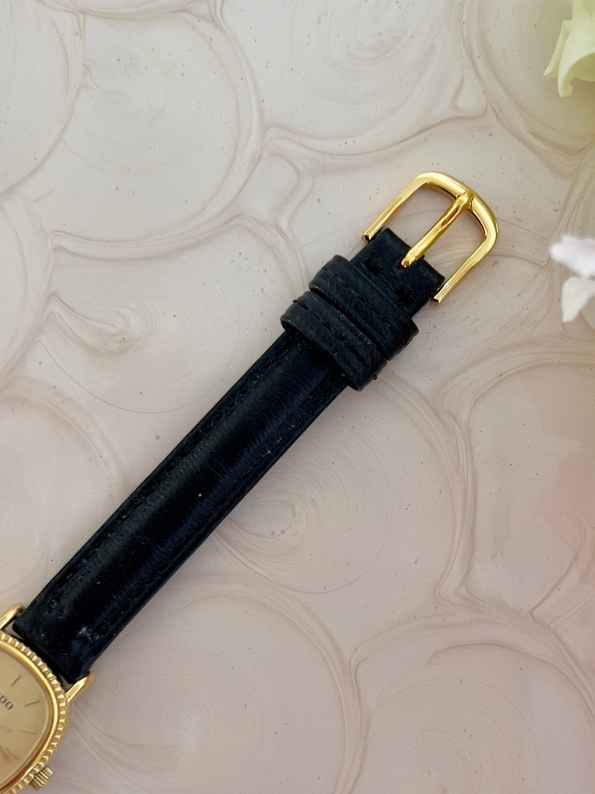 Rado Gold Cushion Women’s Watch with Fluted Case — strap buckle and leather texture.