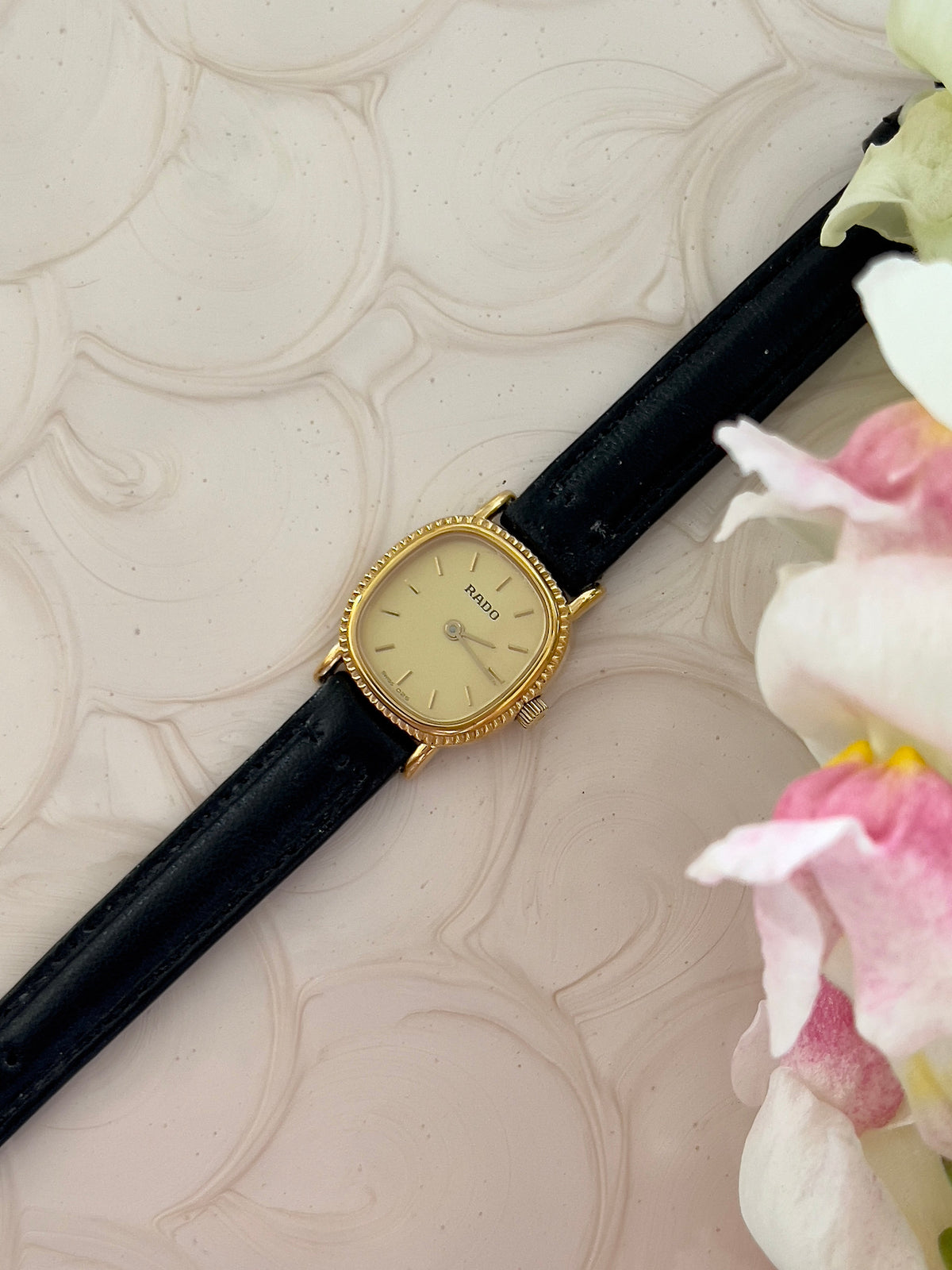 Rado Gold Cushion Women’s Watch with Fluted Case — full watch and black leather strap.