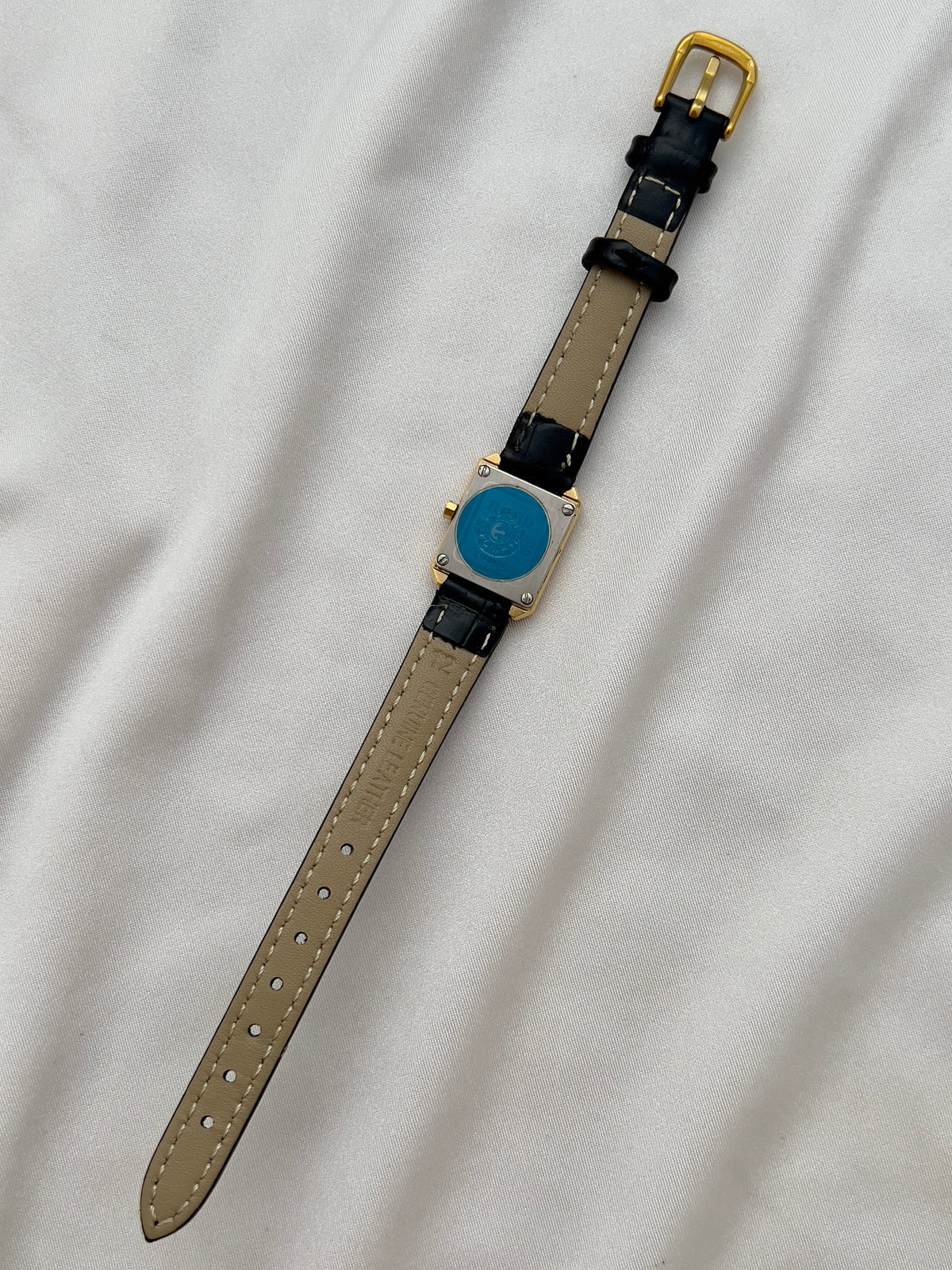 Vintage Rado DiaStar tank women's watch with a champagne dial and black leather strap, shown from the back with the strap extended.