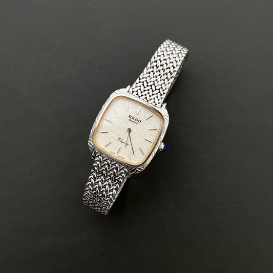 Vintage Rado Elegance silver women's watch with a textured dial and woven bracelet, shown in a close front view.