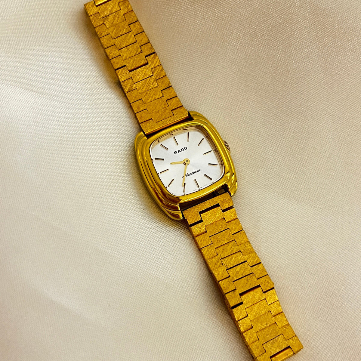 Vintage Rado Moncherie women's watch with a silver dial, double gold-tone frame and bracelet, shown in a full front view.
