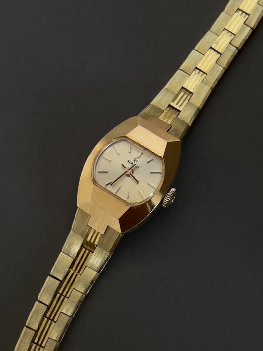 Vintage Rado petite hand-wound women's watch with a gold-tone integrated bracelet, shown in a close front view.