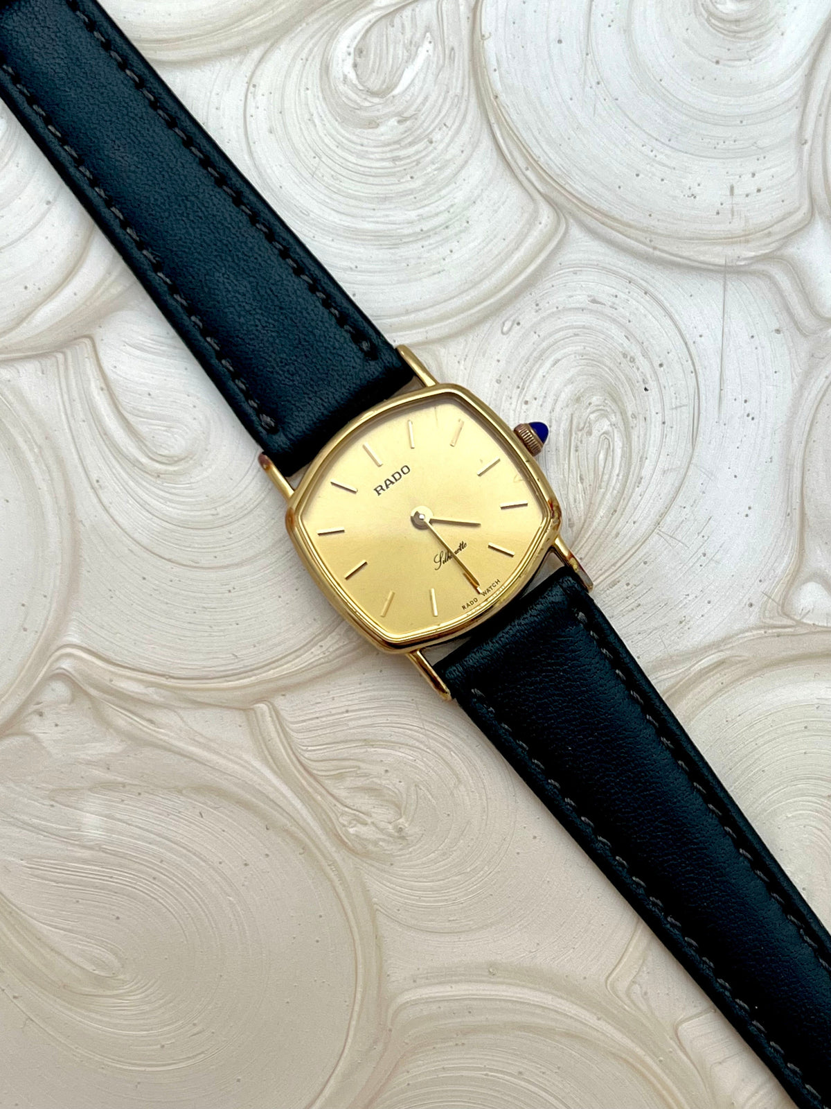 Vintage Rado Soft Octo Silhouette women's watch with a gold-tone case and black leather strap, shown in a detailed dial view.