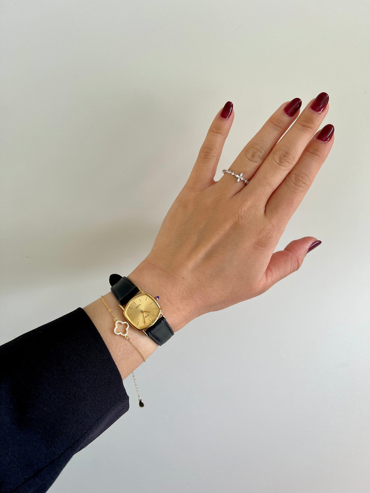 Vintage Rado Soft Octo Silhouette women's watch with a gold-tone case and black leather strap, styled on the wrist with jewellery.