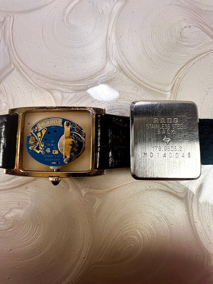 Vintage Rado tank women's watch with a champagne dial, diamond-set case and burgundy leather strap, shown open with the movement and signed caseback.