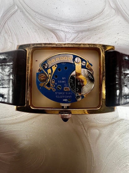 Vintage Rado tank women's watch with a champagne dial, diamond-set case and burgundy leather strap, shown with the case open to reveal the quartz movement.