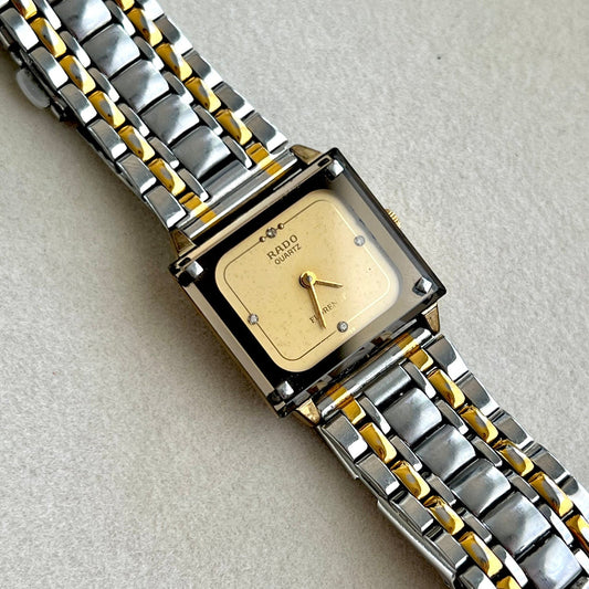 Vintage Rado TV-dial women's watch with diamond markers and a two-tone steel bracelet, shown in a close view of the square dial.