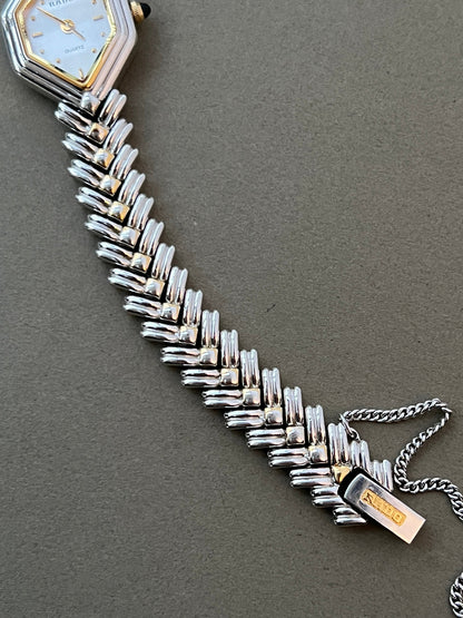 Vintage Rado two-tone sculpted women's watch with a pearl dial and herringbone bracelet, shown in a close detail view.