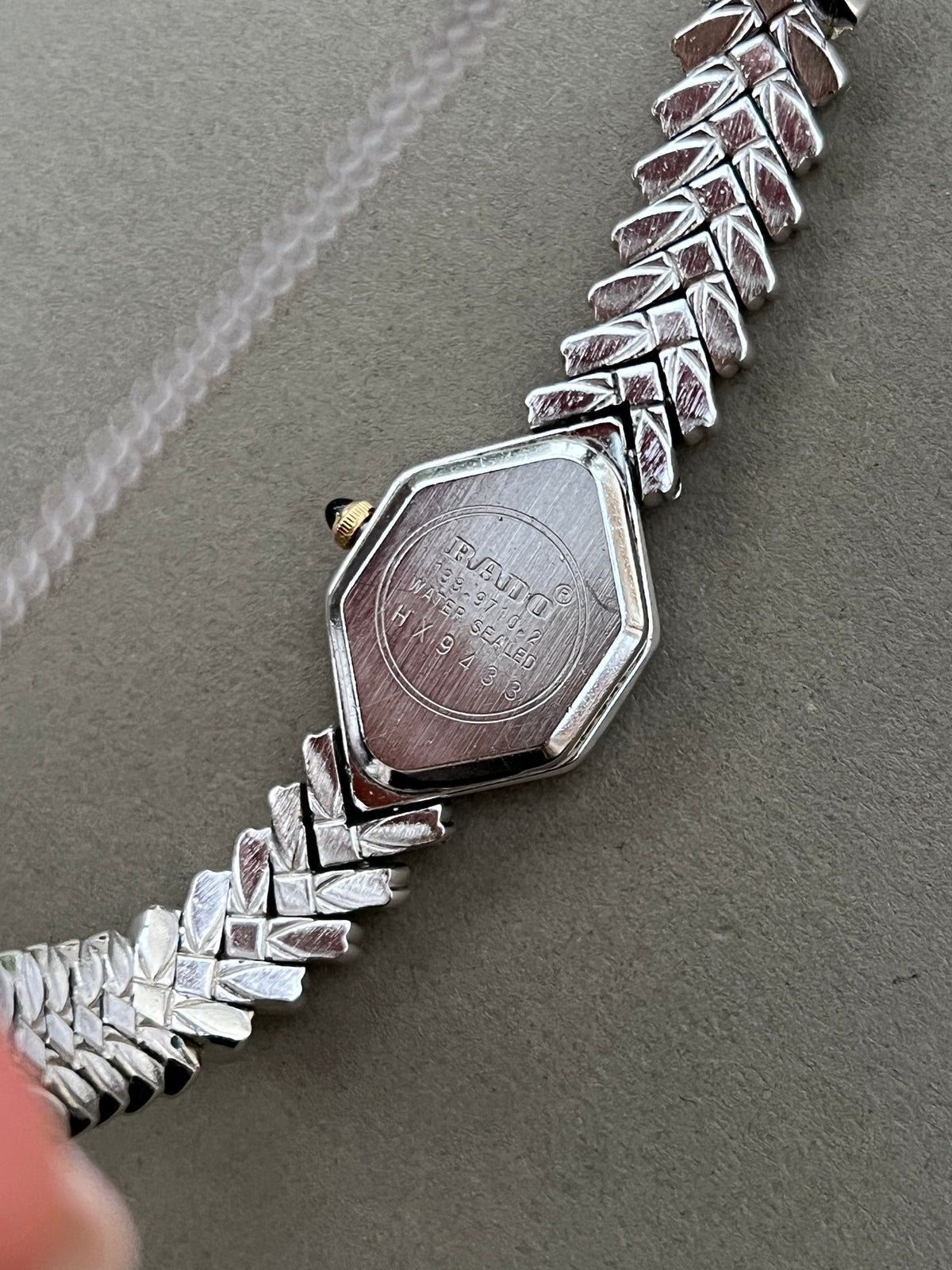 Vintage Rado two-tone sculpted women's watch with a pearl dial and herringbone bracelet, shown from the back.
