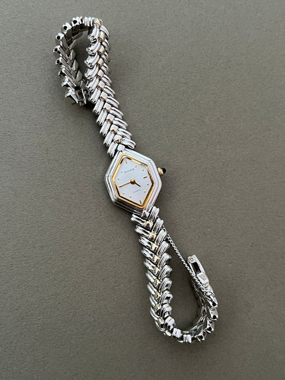 Vintage Rado two-tone sculpted women's watch with a pearl dial and herringbone bracelet, shown with the sculpted bracelet curved.
