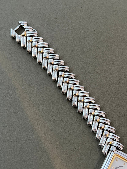 Vintage Rado two-tone sculpted women's watch with a pearl dial and herringbone bracelet, shown with a close view of the herringbone links.