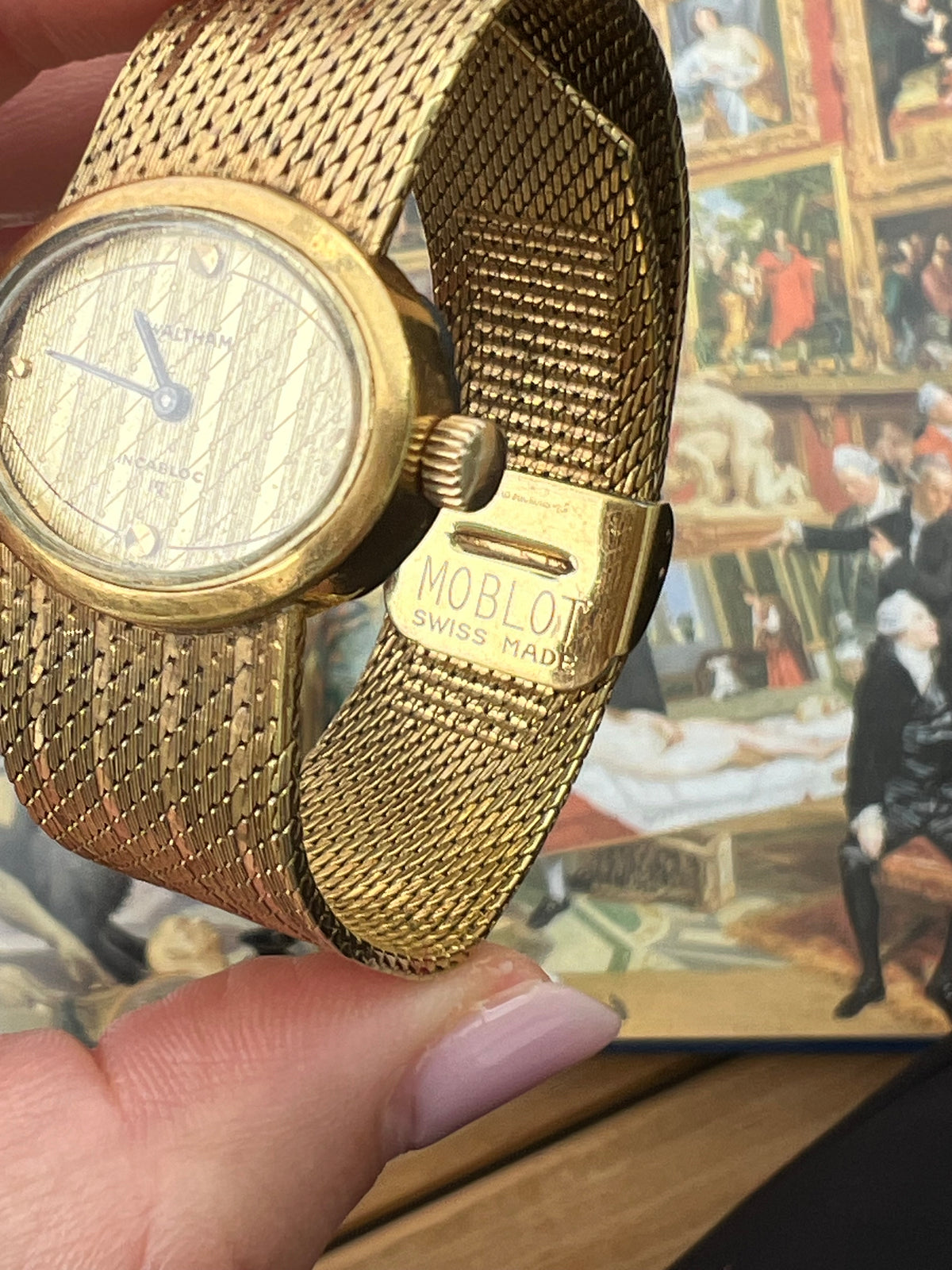 Waltham hand-wound ladies watch with gold-tone oval case and woven mesh bracelet.
