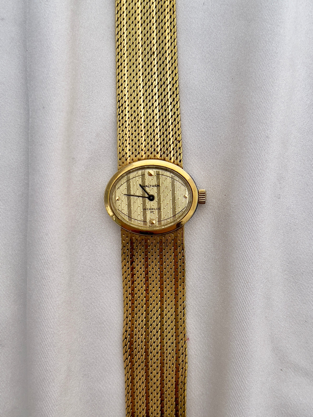 Waltham ladies watch with diagonal textured champagne dial and minimalist markers.