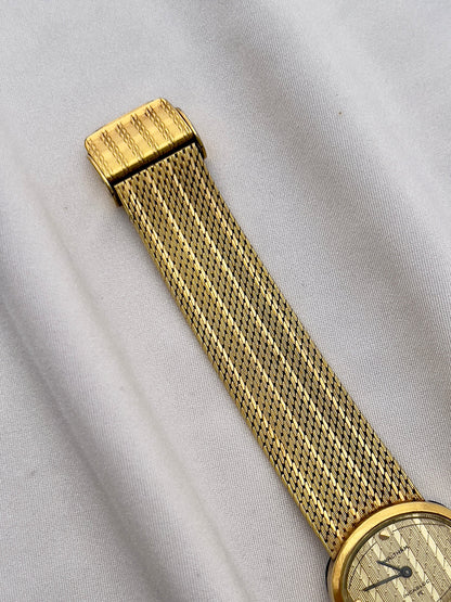 Vintage Waltham mechanical ladies watch with gold-tone case and woven bracelet.