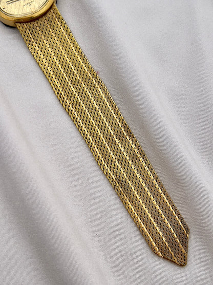 Waltham champagne dial watch with fine diagonal pattern and gold-tone details.