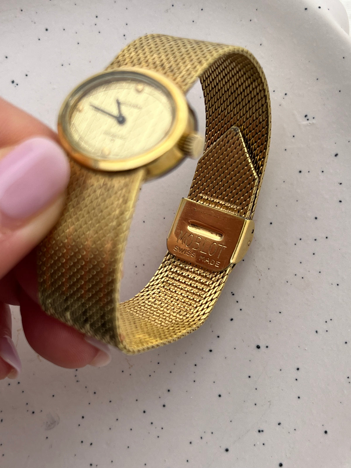 Waltham Swiss mechanical watch with diagonal textured dial and gold-tone bracelet.