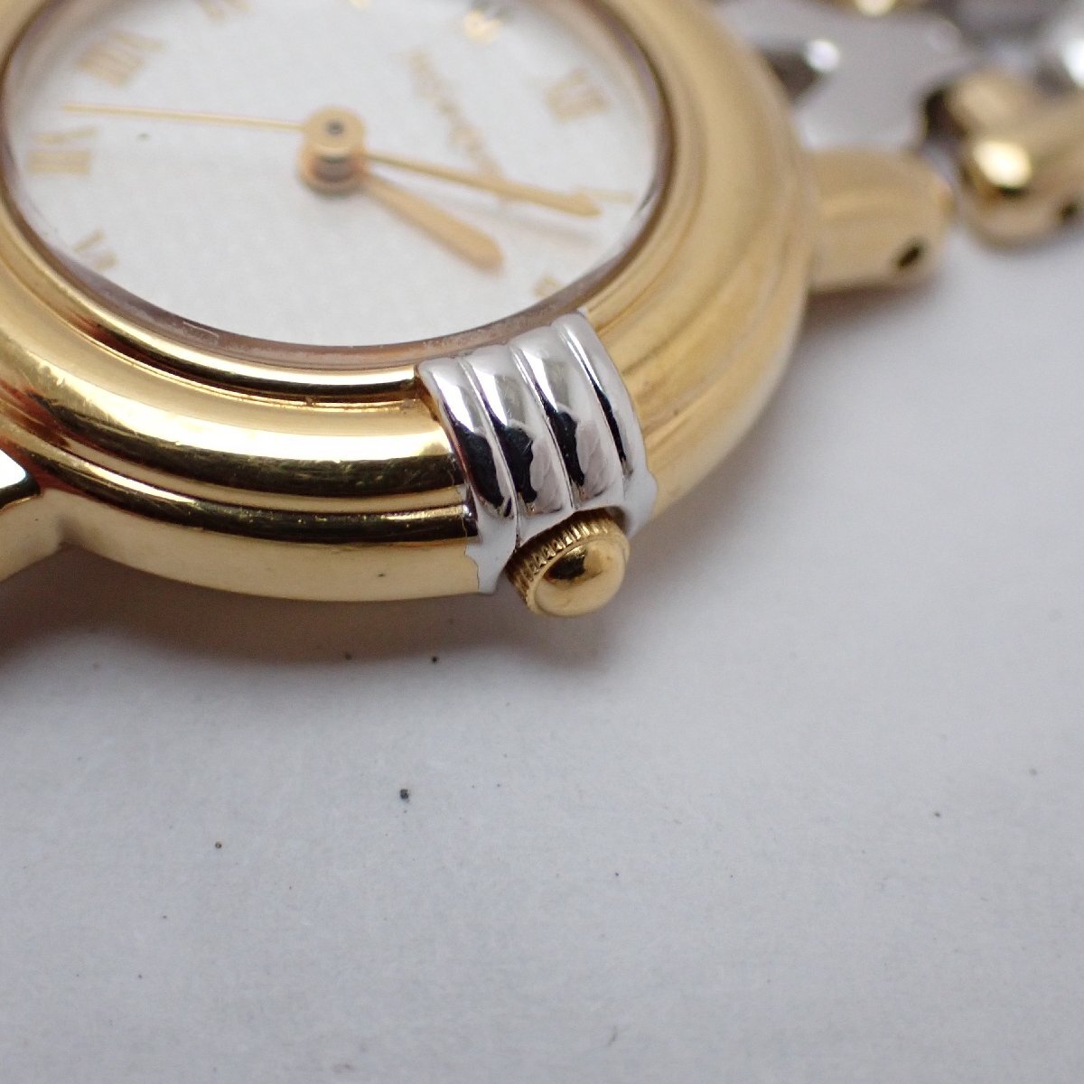 Close view of the Yves Saint Laurent 5430-F43071 gold-tone fluted crown and two-tone case detailing