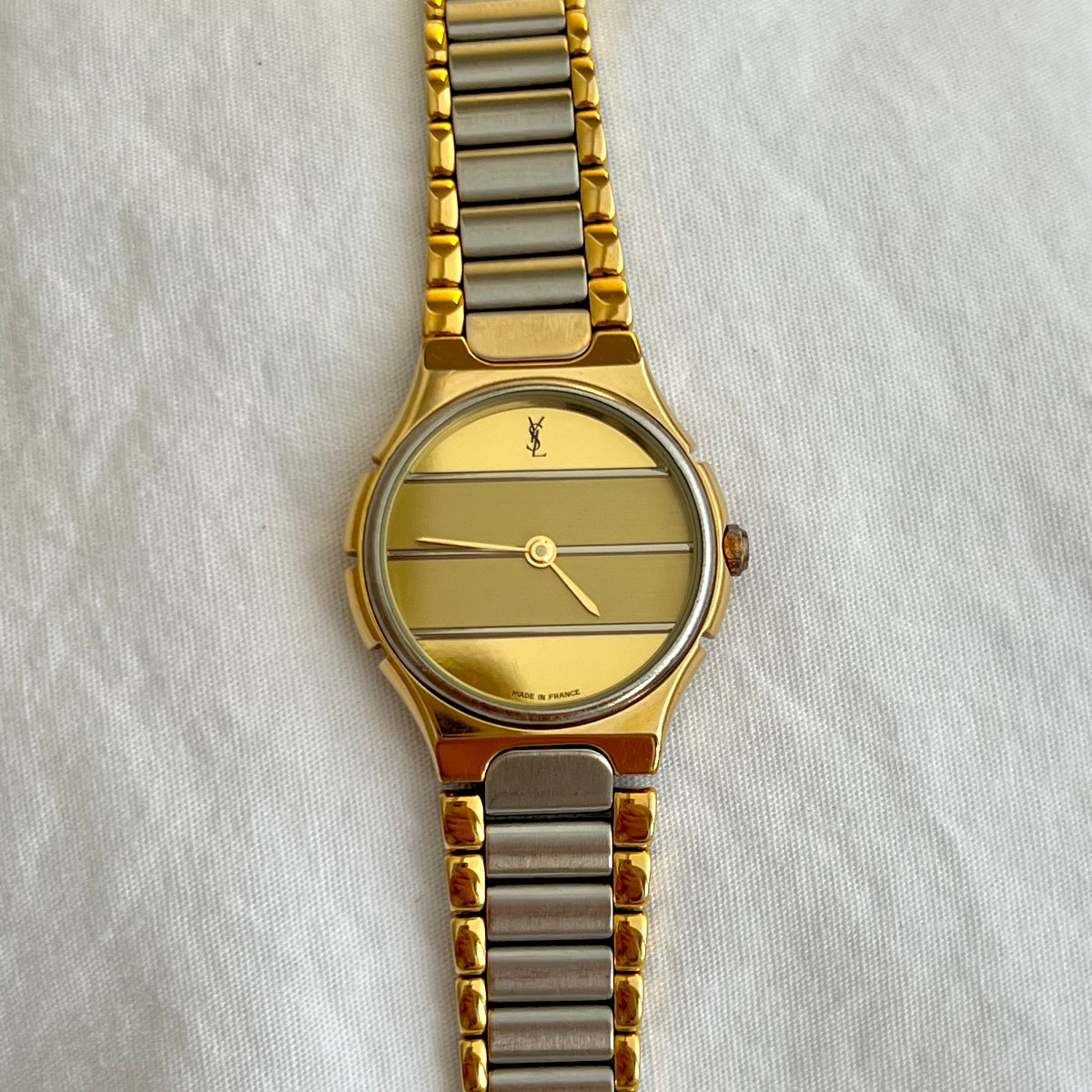 Yves Saint Laurent women's watch with gold striped dial, integrated two tone bracelet and jewellery inspired luxury watch design
